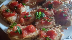 A plate of bruschetta topped with tomatoes and basil. - Private Room With Ensuite Groundfloor (Luqa)