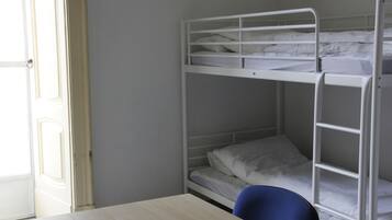 Une chambre avec un lit superposé, un bureau et une chaise en bois.