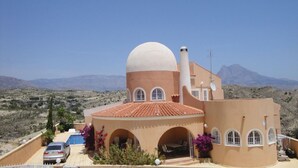 Un bâtiment de style méditerranéen doté d’un dôme, d’arcades et d’une piscine.