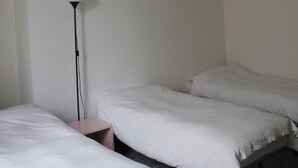 A room with two beds, a floor lamp, and a small bedside table. - Room in B&B - 1bed in Basic 8 Bed Mixed Dorm - Share Bathroom (Naples)