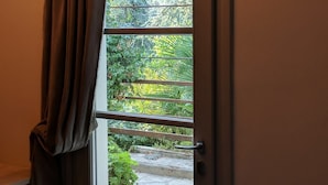 A door with a window, a curtain, and a metal rod. - Room-double Room With Services (San Giuliano Terme)
