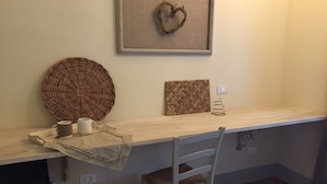 A kitchen with a wooden countertop, a woven basket, a woven placemat, and a chair. - Room-double Room With Services (San Giuliano Terme)