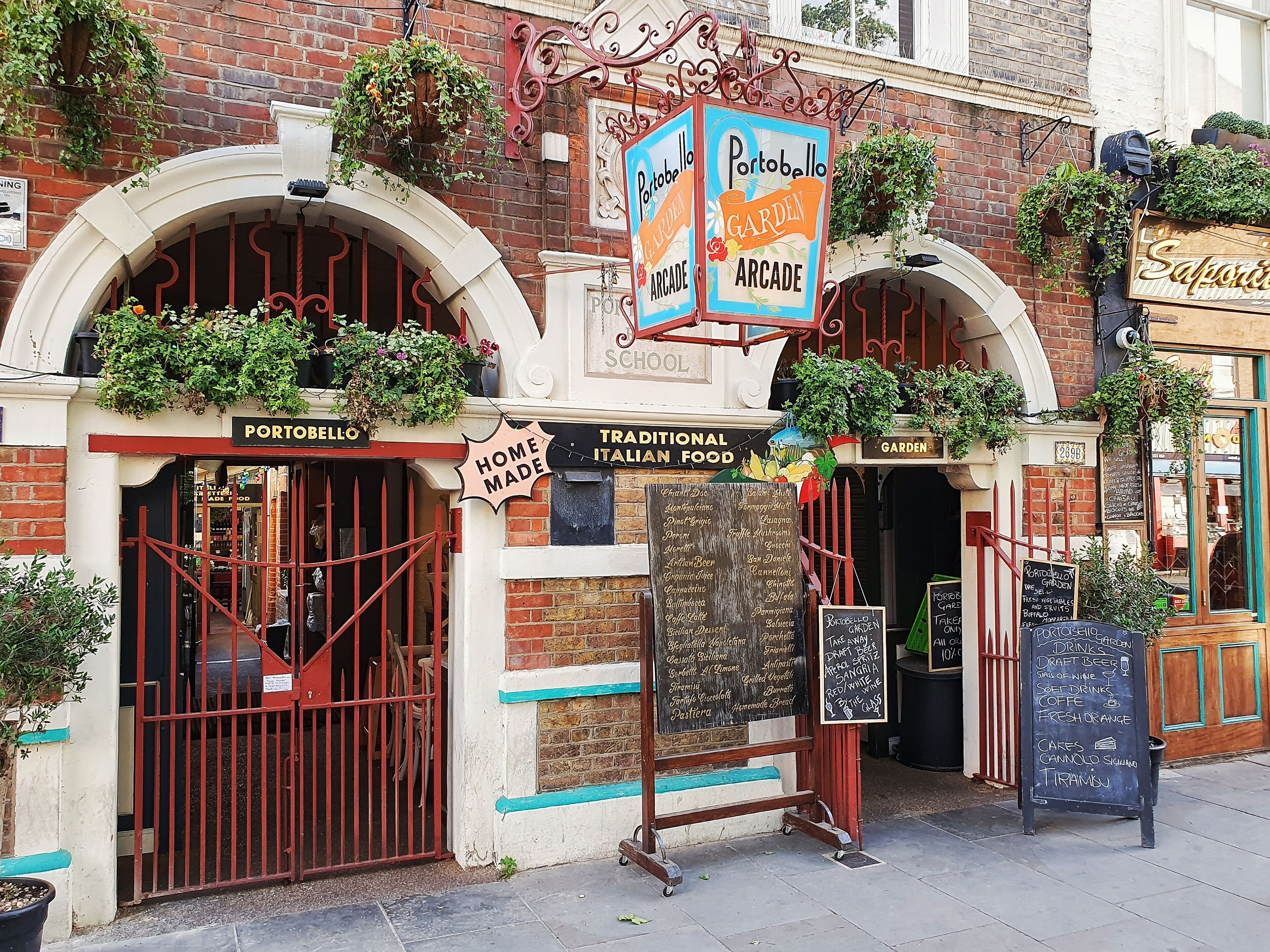 A traditional Italian food restaurant named Portobello Arcade with a signboard listing various dishes.