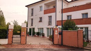 A multi-story building with a gated entrance, potted plants, and a sign indicating a bed and breakfast rental room. - Venice Mestre Tourist Accommodation, Quiet Room With Wifi and Free Parking (Mestre)