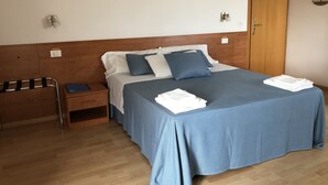 A neatly made bed with blue bedding, a wooden headboard, and a nightstand with a lamp. - Venice Mestre Tourist Accommodation, Quiet Room With Wifi and Free Parking (Mestre)