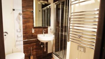 A modern bathroom with a white toilet, a sink, and a glass-enclosed shower.