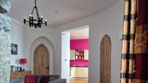 Ein Wohnzimmer mit grauem Sofa, einem Holztisch und einem roten Teppich.