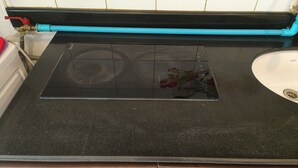 A kitchen with a black countertop, a stove, a sink, and a blue pipe. - 305 Jomtien Hill Resort (Pattaya)