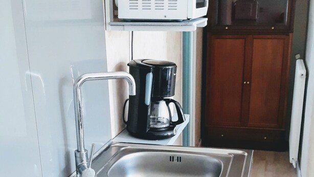 A kitchen with a built-in stove, a coffee maker, and a microwave above the stove.