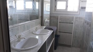 A bathroom with two sinks, a mirror, and a towel rack.