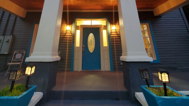 A two-story building with a central entrance, a balcony on the upper floor, and a set of stairs leading to the entrance. - New Lower Rates! Amazing 8 Bedroom 3 Story Downtown Hot Springs! No Admin Fee!! (Hot Springs)