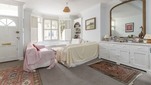A bedroom with a bed, a large mirror, a dresser, and a window with shutters. - JOIVY Charming 3 bed house with a rooftop terrace (London)