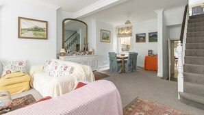A bedroom with a bed, a dresser, a mirror, a window with a view, and a staircase. - JOIVY Charming 3 bed house with a rooftop terrace (London)