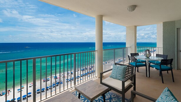 Ein Balkon mit Blick auf Strand und Meer.