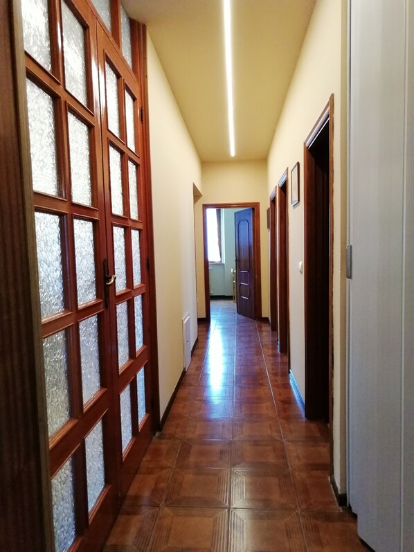 A hallway with wooden doors and a tiled floor.