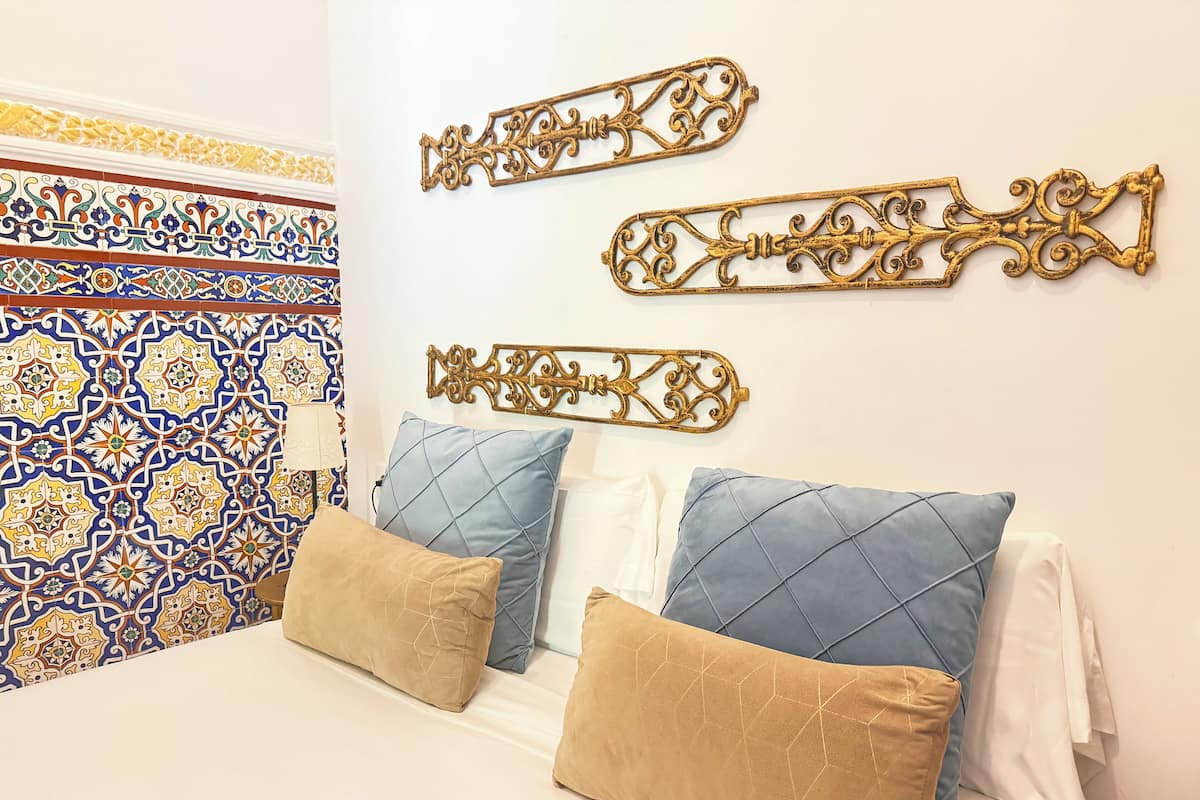 A bed with two pillows, a headboard, and decorative wall art.