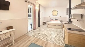 Una habitación pequeña con cama, mesitas de noche, televisor y microondas.