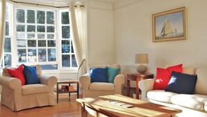 Ein Wohnzimmer mit zwei Sofas, einem Couchtisch und einem Bild an der Wand.