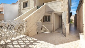 A building with a stone staircase leading to a door, a white fence, and a clear sky. - Residence Aquarium (Torricella)