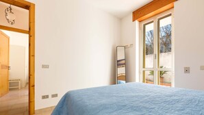 A bedroom with a bed, a mirror, and a view of the outside. - Villetta Amilcare (Lecce)