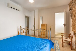 A bedroom with a bed, a wardrobe, a mirror, and a door leading to a balcony. - Appartamento Felline (Alliste)