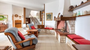 A spacious living area with a fireplace, wooden furniture, and a staircase leading to another level. - Villa Alice (Porto Cesareo)