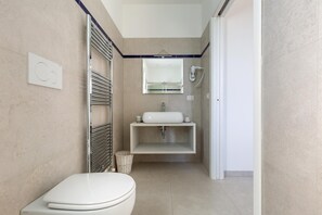 A modern bathroom with a toilet, a sink, and a mirror.