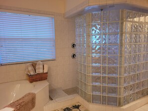 Tina con regadera, tina de hidromasaje, secadora de cabello, toallas 