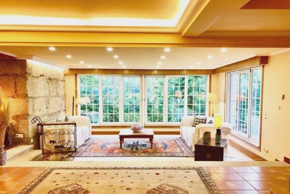 Cozy retreat with a traditional fireplace, comfortable seating area, and large windows.