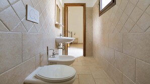 Un baño pequeño con inodoro, bidé y lavamanos.