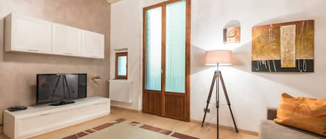 Apartment, 1 Bedroom, Balcony | Living area | Flat-screen TV, books