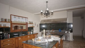 A kitchen with wooden cabinets, a granite countertop, a stove, and a sink. - Room-authentic Boutique Hotel (Fethiye)
