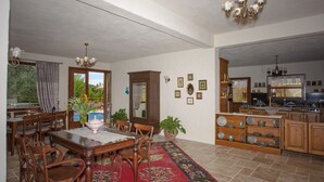 A spacious dining area with wooden furniture, a red floral rug, and a view of the outdoors through a window. - Room-exclusive Boutique Hotel 4 (Fethiye)