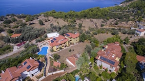 An aerial view of a residential area with houses, a swimming pool, and a view of the sea. - Room-exclusive Boutique Hotel 4 (Fethiye)