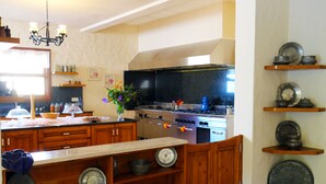 A kitchen with wooden cabinets, a central island, a stove, and various kitchen utensils. - Room-exclusive Boutique Hotel 4 (Fethiye)