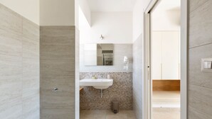 Une salle de bain moderne avec un lavabo, un miroir et un espace douche.