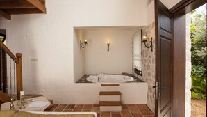 A bathroom with a bathtub, wooden steps, a door, and wall-mounted lights. - Room-exclusive Boutique Hotel 3 (Fethiye)