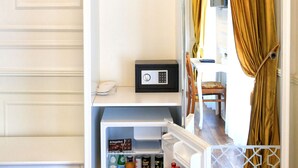 Une armoire blanche équipée d’un mini-réfrigérateur intégré contenant des boissons et un petit appareil électronique.