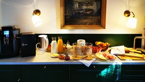 Una encimera de cocina con una máquina de café, un hervidor y diferentes alimentos.