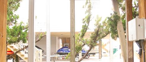 A covered outdoor area with a white railing, a small patch of artificial grass, and a wooden structure.
