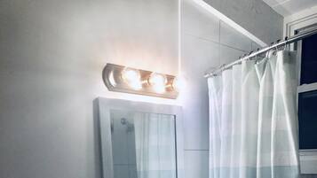 A bathroom with a sink, toilet, and mirror.