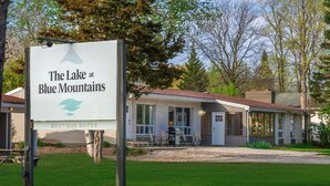 A sign for "The Lake at Blue Mountains Boutique Suites" with a view of a building with a covered patio and a lawn. - Mountain View Boutique Suite with contactless entry - The Lake at Blue Mountains (The Blue Mountains)