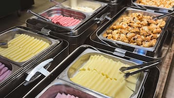 Ein Buffet mit verschiedenen Speisen, darunter Aufschnitt, Käse und Gebäck.