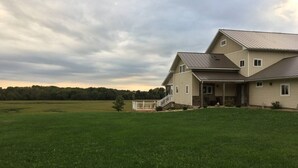 A two-story house with a large front porch and a spacious lawn. - Private Peaceful Country Getaway - Family Friendly - Illinois (Berwick)