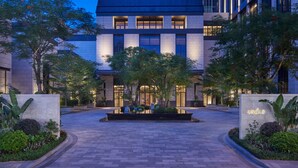 A modern building with a courtyard, featuring a well-lit entrance and surrounding greenery. - ANDAZ XIAMEN, BY HYATT (Xiamen)