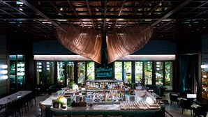 A bar area with a high ceiling, a bar counter, and seating. - ANDAZ XIAMEN, BY HYATT (Xiamen)