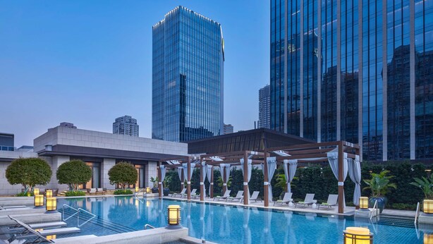 A rooftop pool with lounge chairs, a pergola, and cityscape views. - ANDAZ XIAMEN, BY HYATT (Xiamen)