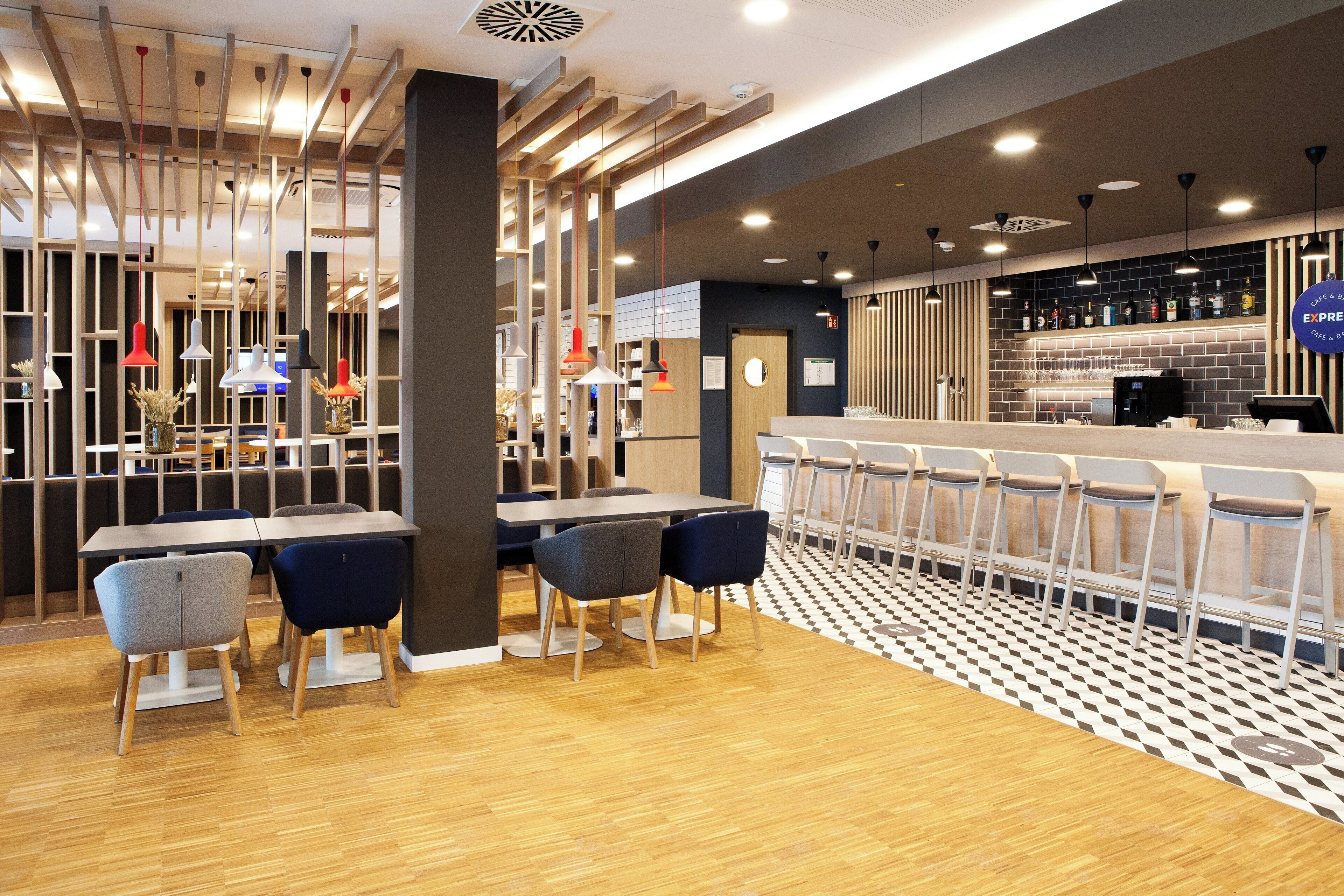 A modern bar area with a counter, seating, and a patterned floor.