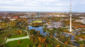 Oversigtsbillede af en bypark med et stort stadion, et tårn og omkringliggende bygninger.