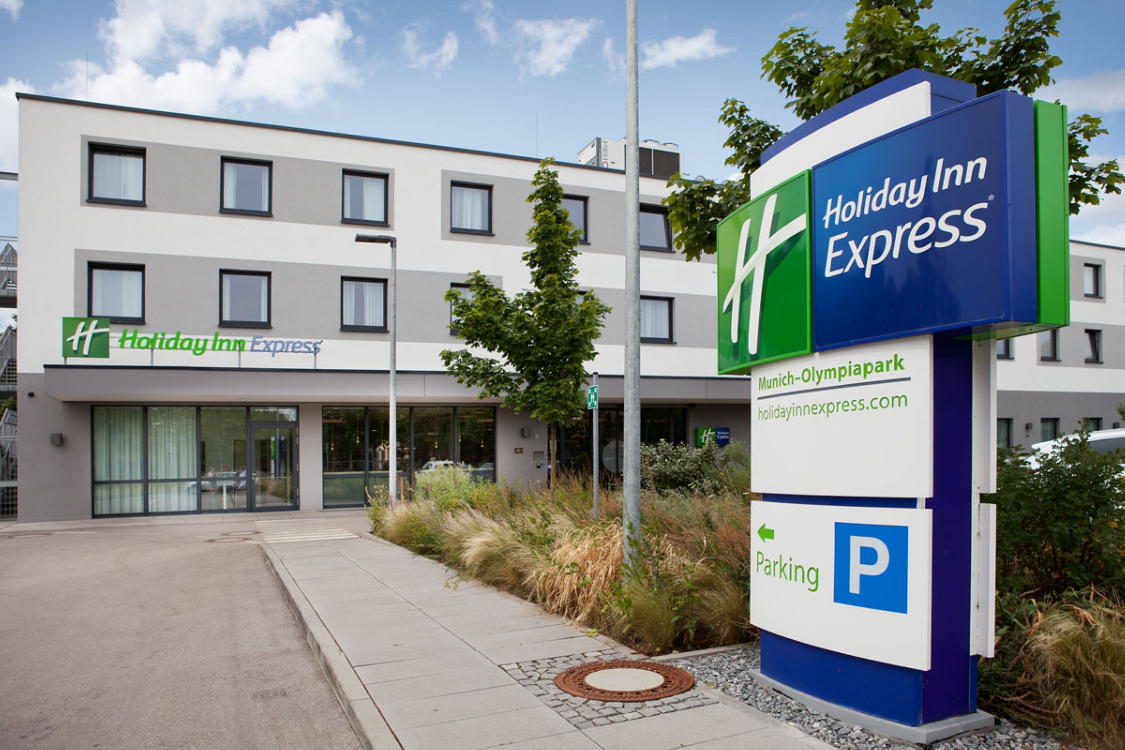 Un bâtiment de l’hôtel Holiday Inn Express avec un panneau bien visible indiquant l’emplacement du parking.